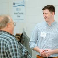 An engineering student speaking with guests at the Engineering Design Project Preview